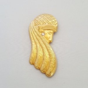 Goudkleurige broche vrouwenhoofd